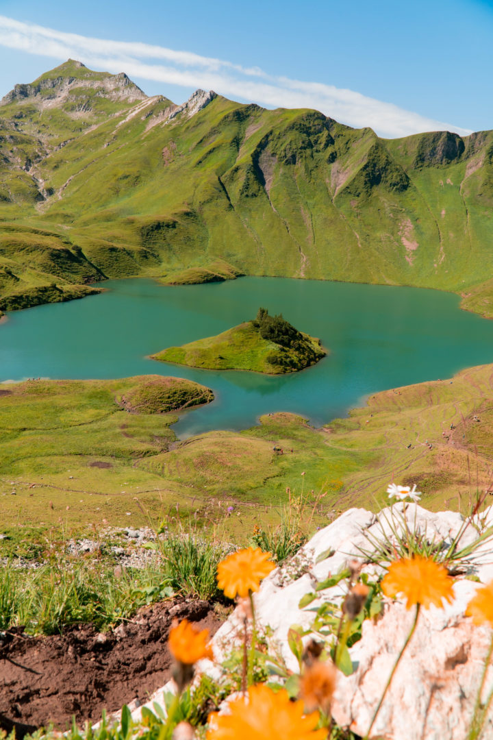 kristallblauer Bergsee, genannt Schrecksee mit kleiner Insel in der Mitte, im Grenzgebiet der österreichischen und allgäuer Alpen.