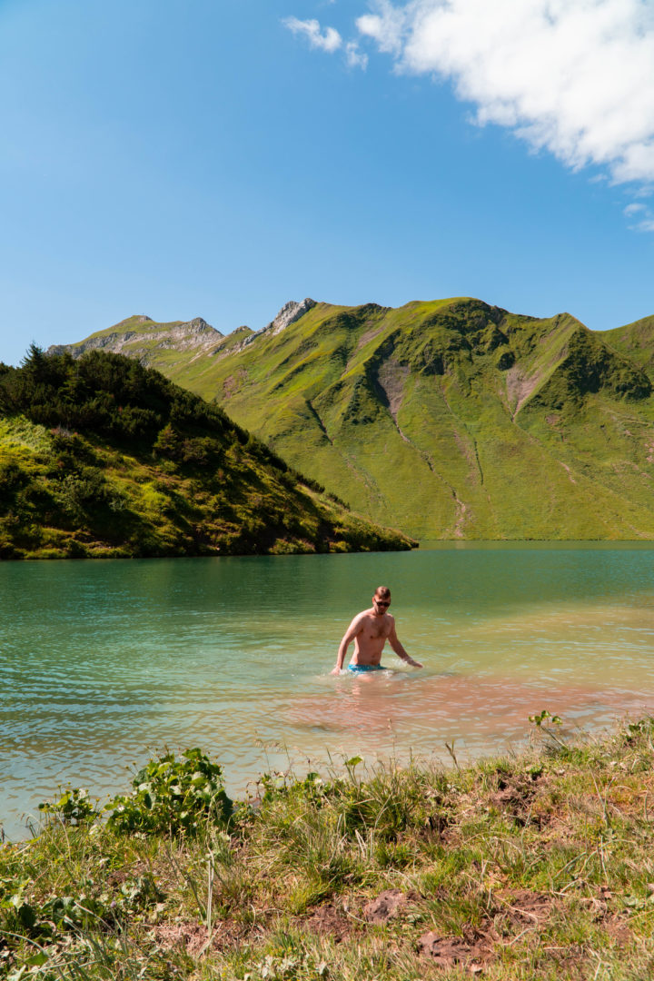 Badende im Bergsee, genannt Schrecksee mit kleiner Insel in der Mitte, im Grenzgebiet der österreichischen und allgäuer Alpen.