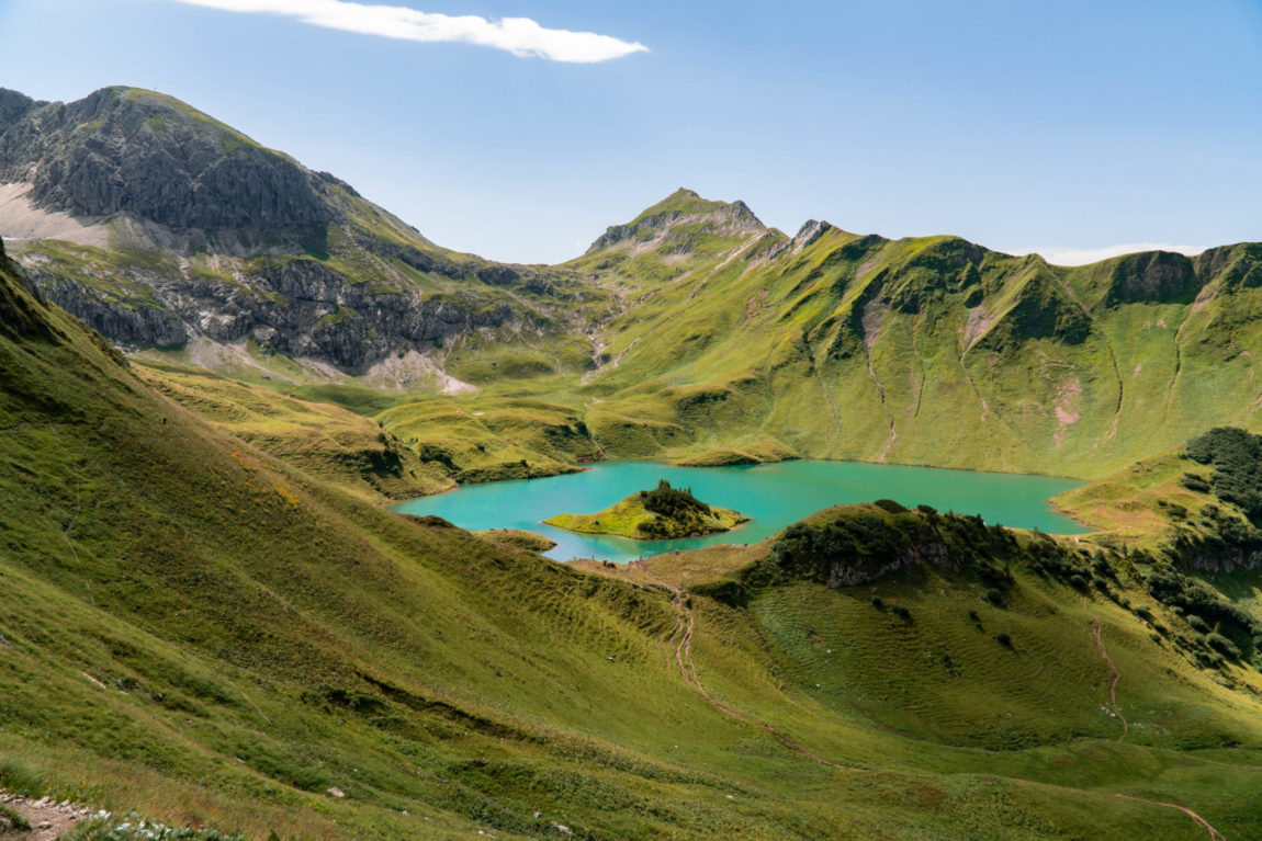 kristallblauer Bergsee, genannt Schrecksee mit kleiner Insel in der Mitte, im Grenzgebiet der österreichischen und allgäuer Alpen.