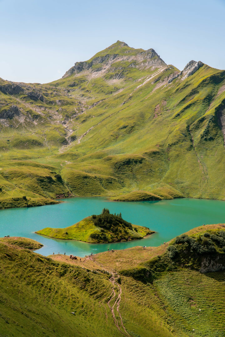 kristallblauer Bergsee, genannt Schrecksee mit kleiner Insel in der Mitte, im Grenzgebiet der österreichischen und allgäuer Alpen.