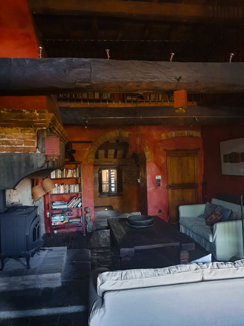 Wohnzimmer mit roten Steinwänden und großem Kamin in altem Umbrischen Bauernhaus.