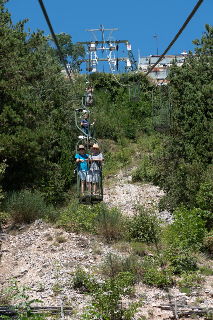 Seilbahn in Guibbio Funivia Colle Eletto, bei der man in einem Korb stehend transportiert wird.