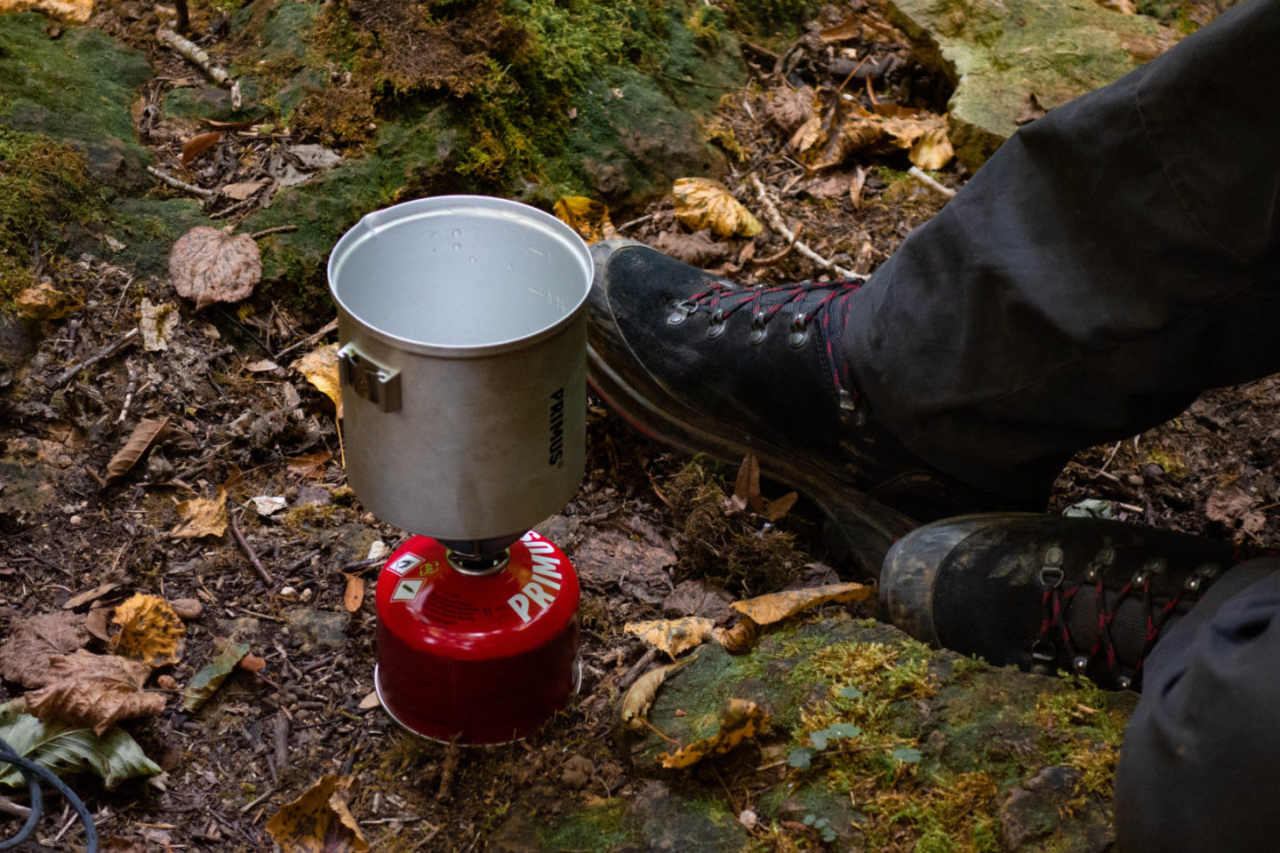 Campingkocher mit heißem Wasser im Wald.